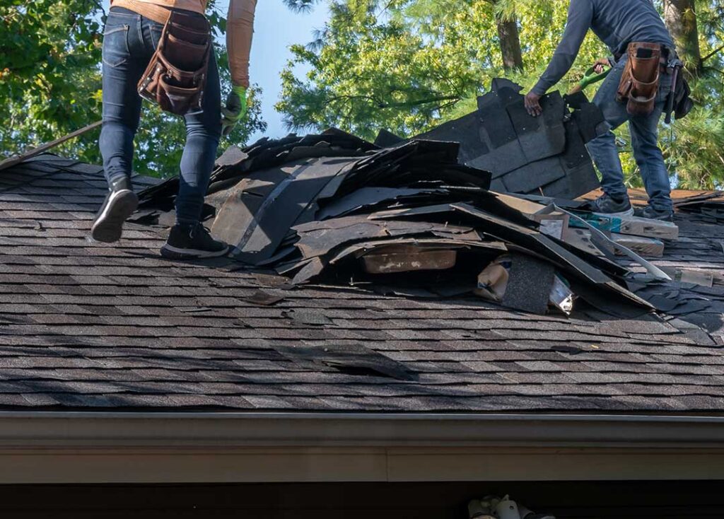 Building inspector examining roof framing, flashing, and underlayment on a residential house.
